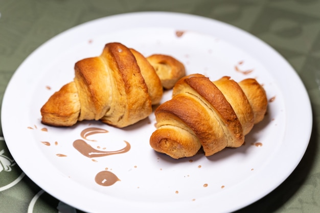 Plat avec une paire de croissants décorés de crème au chocolat dans un restaurant