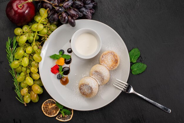 Plat de pancekes au fromage avec sirop sur fond de bois