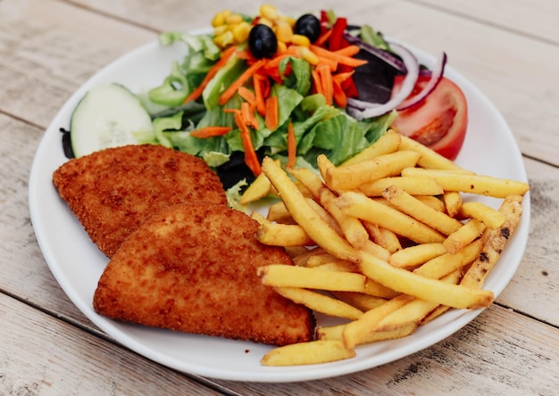 Plat de poitrine de poulet panée et frite accompagnée de frites