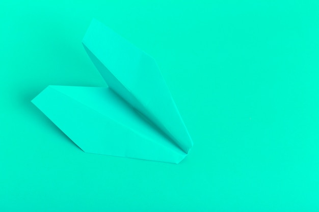 Plat poser d'un avion en papier sur fond de couleur pastel vert