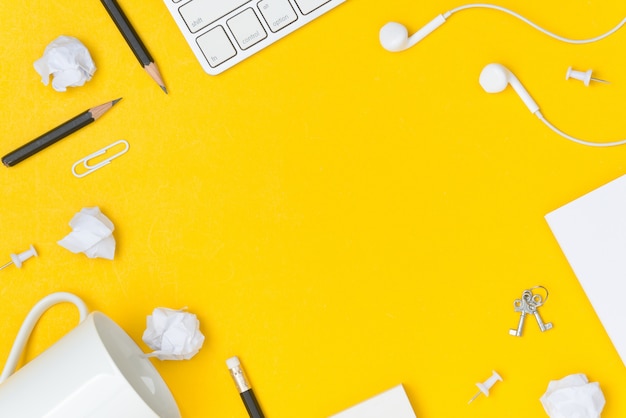 Plat poser de l&#39;espace de travail de bureau avec une feuille de papier espace vide sur fond jaune