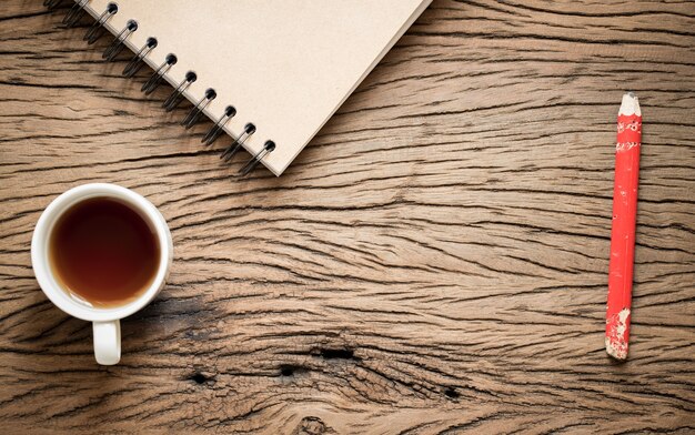 Photo plat poser photo de vieux bois avec un cahier et un verre de thé.espace est en bois à motifs.focus sur le plancher en bois