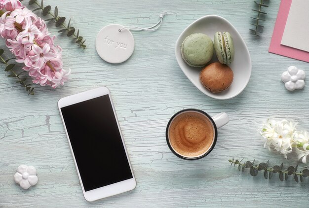 Plat de printemps avec café, macarons, fleurs de jacinthes, eucalyptus et décorations