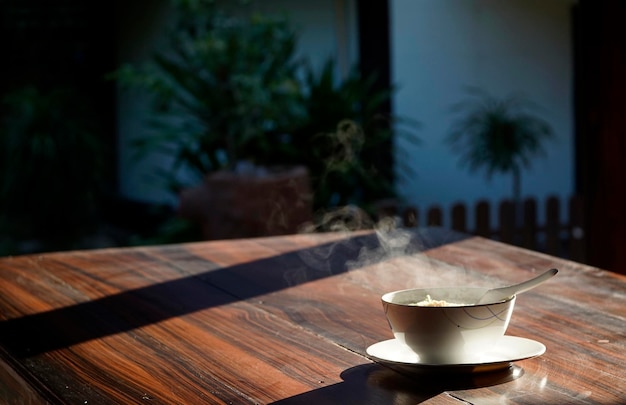 Un plat de riz bouilli avec une belle vapeur sur une table en bois un matin