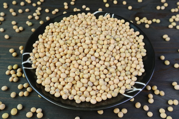 Un plat de soja séché avec des haricots éparpillés sur une table en bois noir