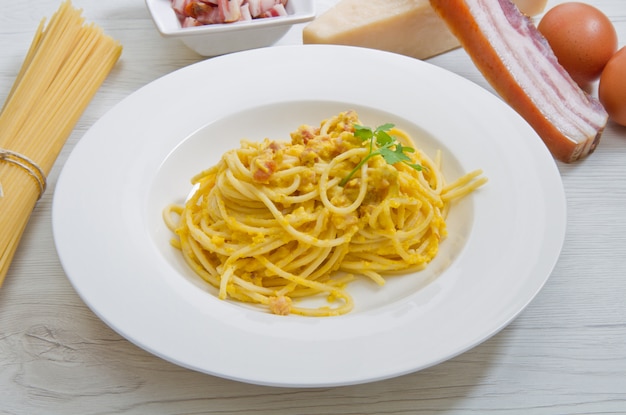 Plat avec des spaghettis de carbonara et des ingrédients