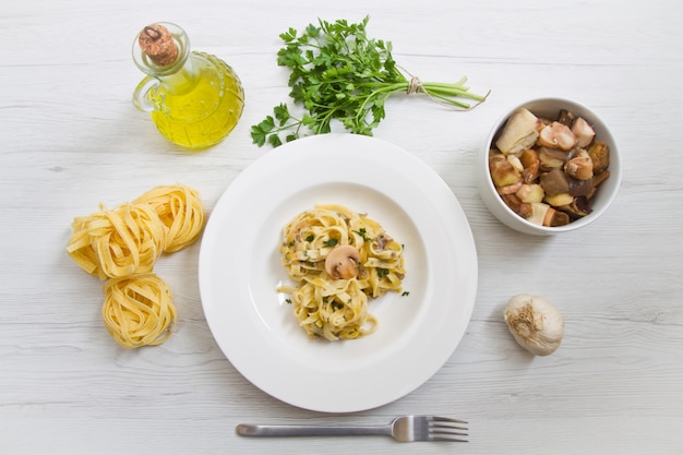 Plat avec tagliatelles et champignons et ingrédients frais