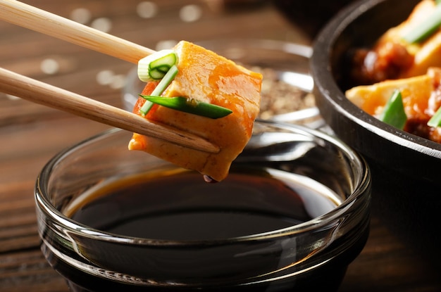 Plat de tofu mapo de caillé de soja morceau tenu dans des baguettes