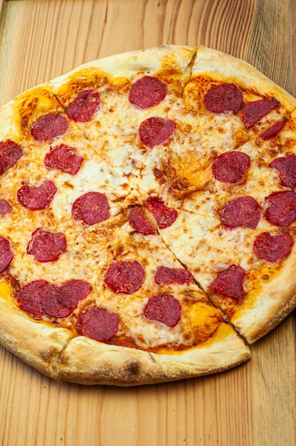 plat traditionnel classique pizza au pepperoni avec saucisse Cuisine italienne sur fond de bois