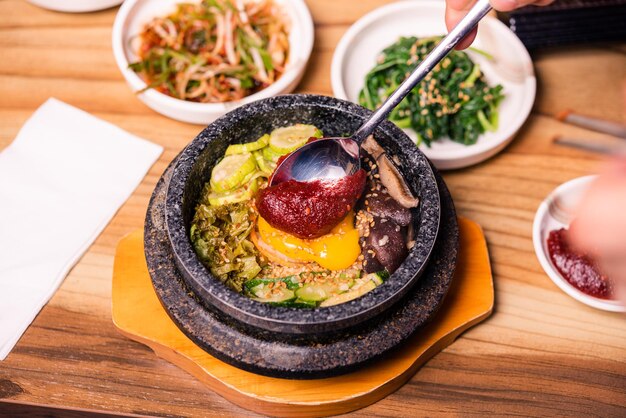 Plat traditionnel coréen bibimbap riz mélangé avec des légumes Inclure le bœuf et l'œuf au plat