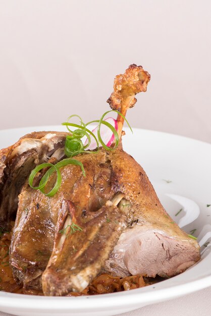 Plat traditionnel avec du canard au four et du chou aigre, décoré avec des herbes