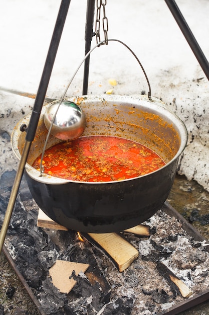 Plat traditionnel hongrois - goulasch de bogracs, ragoût de viande et légumes dans un chaudron, à l'extérieur dans une cheminée d'hiver