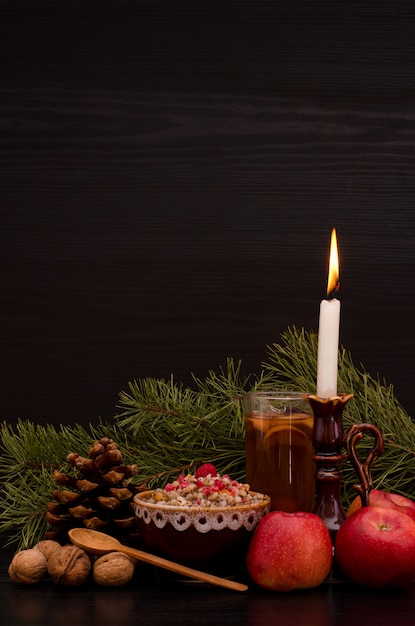 Plat traditionnel de Noël chez les Slaves. Bougie, pommes, boisson et pin