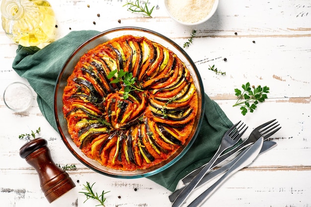 Photo plat végétalien ratatouille fait de légumes dans un plat de cuisson sur un fond rustique en bois