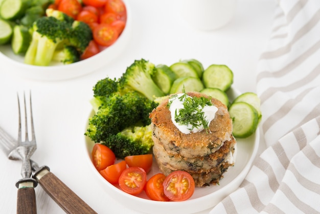 Plat végétarien de galettes de pommes de terre aux herbes et légumes sur une assiette