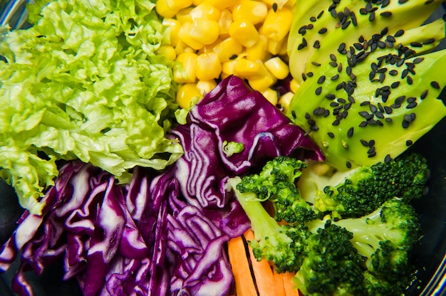 Plat végétarien, saladier. Ingrédients brocoli, maïs, carottes, couscous, laitue, chou