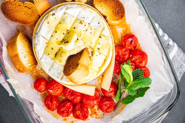 Un plat en verre de fromage avec une fourchette et un brin de menthe dessus.