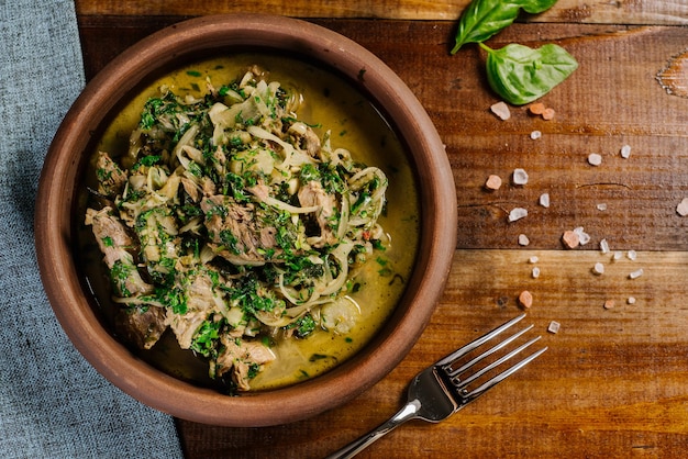 Plat de viande hachée avec sauce et herbes sur le fond en bois