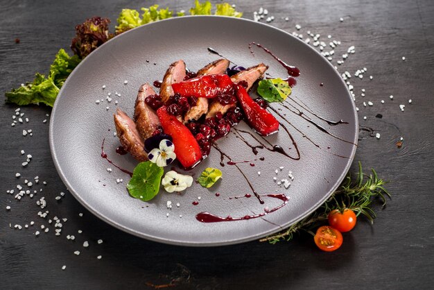 Un plat de viande de porc avec des légumes sur fond de bois