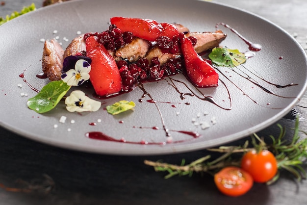 Un plat de viande de porc avec des légumes sur fond de bois