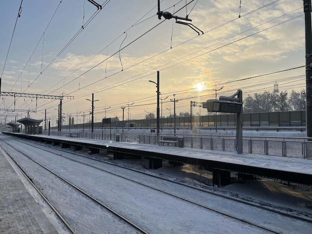 Plate-forme ferroviaire vide sans passagers en hiver au coucher du soleil. Chemin de fer, concept de temps froid