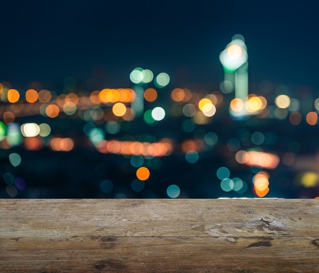 Plateau en bois avec arrière-plan flou abstrait de la nuit de bangkok, lumières du centre-ville avec bokeh