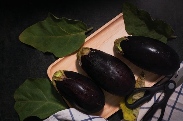 Un plateau en bois avec des aubergines dessus