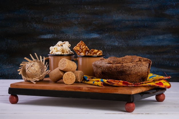 Plateau en bois avec gâteau pop-corn et bonbons de festa junina