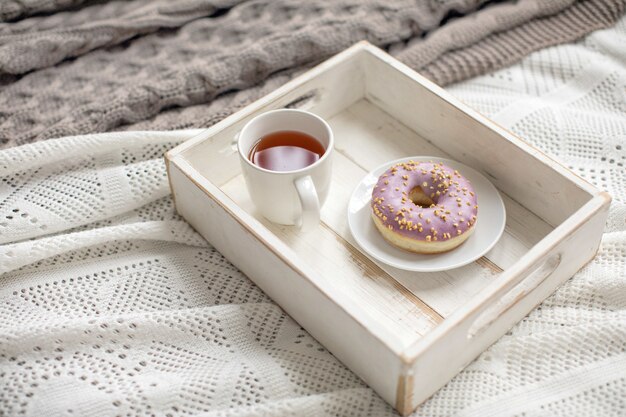 Plateau en bois avec thé et beignet