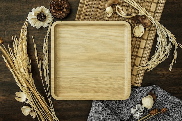 Plateau en bois vide, décoré d'un riz et de céréales sur table en bois