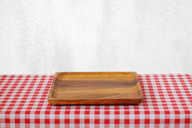 Photo plateau en bois vide sur la table avec une nappe rouge