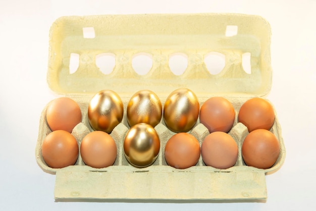 Un plateau en carton avec des œufs d'or brun, un emballage avec des oeufs de Pâques décoratifs teints.