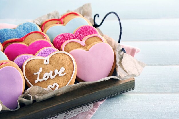 Plateau avec des cookies d'amour sur fond de table en bois bleu