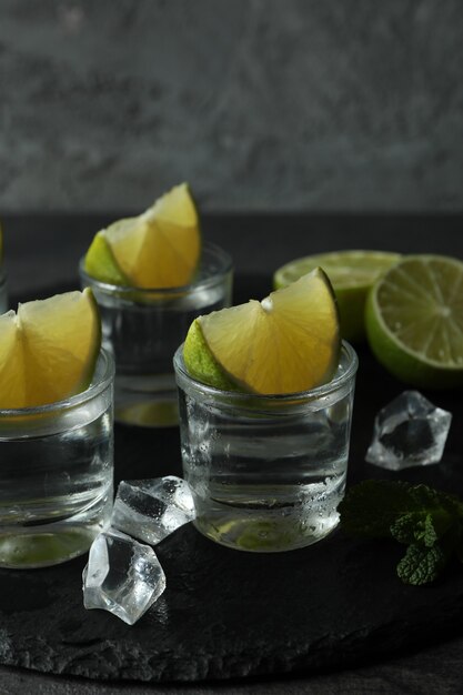 Plateau avec des coups de vodka, citron vert, menthe et glace