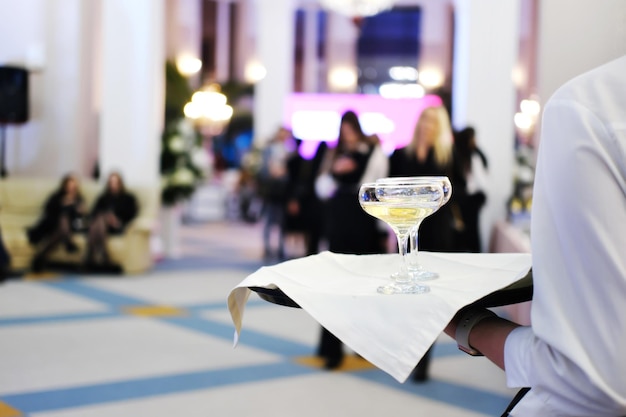 Plateau avec deux verres de champagne Le serveur sert du champagne aux invités de l'événement