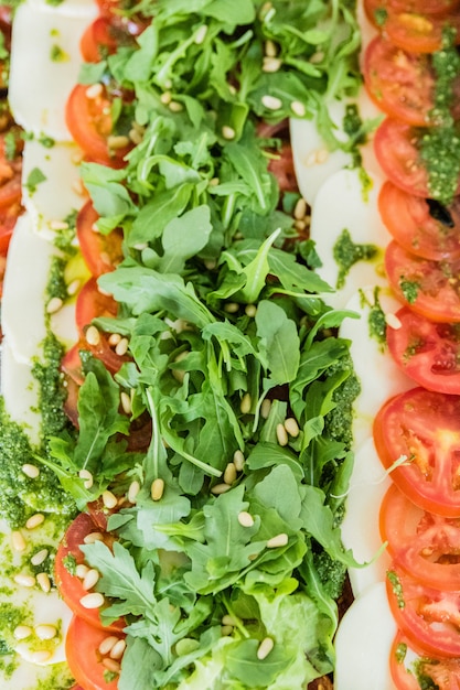 Plateau avec fromage mozzarella, tomate et laitue pour un buffet