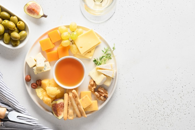 Plateau de fromages avec raisins noix figues sur fond blanc vue de dessus copie espace