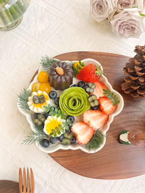 Un plateau de fruits avec une assiette blanche avec une rose blanche dessus.