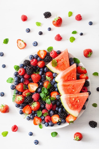 Plateau de fruits et de baies sur blanc. myrtille, fraise, framboise, mûre, pastèque