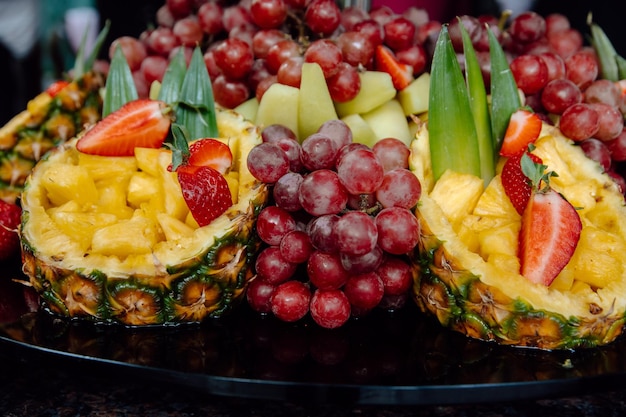 Un plateau de fruits avec une grappe de raisin et d'autres fruits