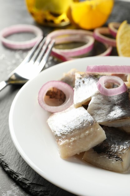 Plateau noir avec assiette de tranches de poisson hareng frais