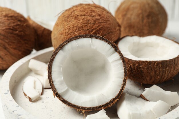 Plateau avec noix de coco sur table en bois, gros plan. Fruit exotique