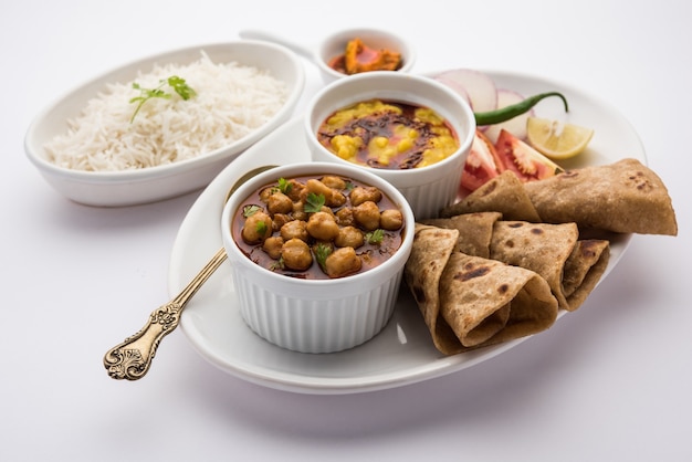 Plateau de nourriture indienne ou thali végétarien comprend Dal Fry, riz, Chapati et un type de légume avec salade