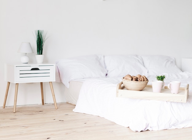 Photo plateau avec petit-déjeuner au lit dans une chambre lumineuse