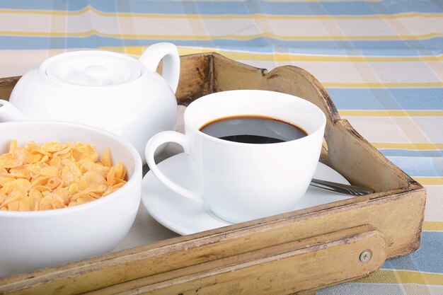 Plateau petit-déjeuner avec café et céréales.