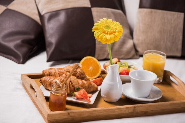 Plateau avec petit-déjeuner sur le lit à l'intérieur d'une chambre