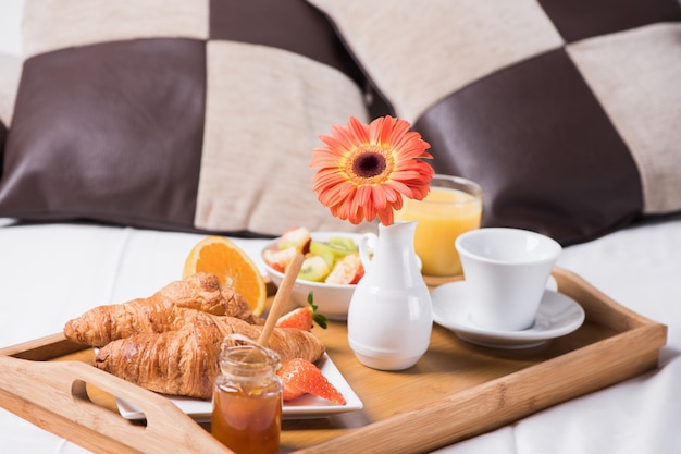 Plateau avec petit-déjeuner sur le lit à l'intérieur d'une chambre