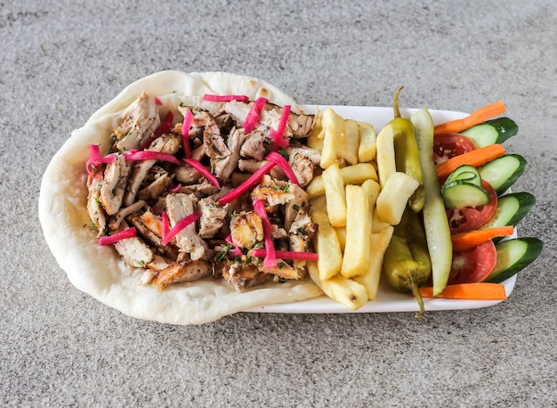 Plateau de poulet shawarma avec frites et salade servi dans un plat isolé sur fond vue de dessus de restauration rapide