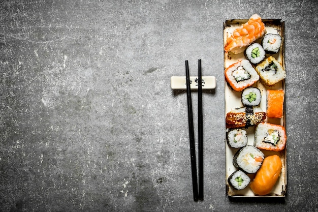 Plateau de rouleaux de sushi et de fruits de mer. Sur la table en pierre.