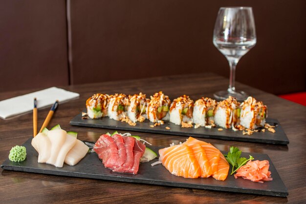 Plateau de superbes filets de sashimi crus assortis au saumon norvégien, au thon rouge de la Méditerranée et au poisson manquilla au wasabi et au ginseng